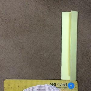 Fold a sticky note to make a half inch wide paper strip.